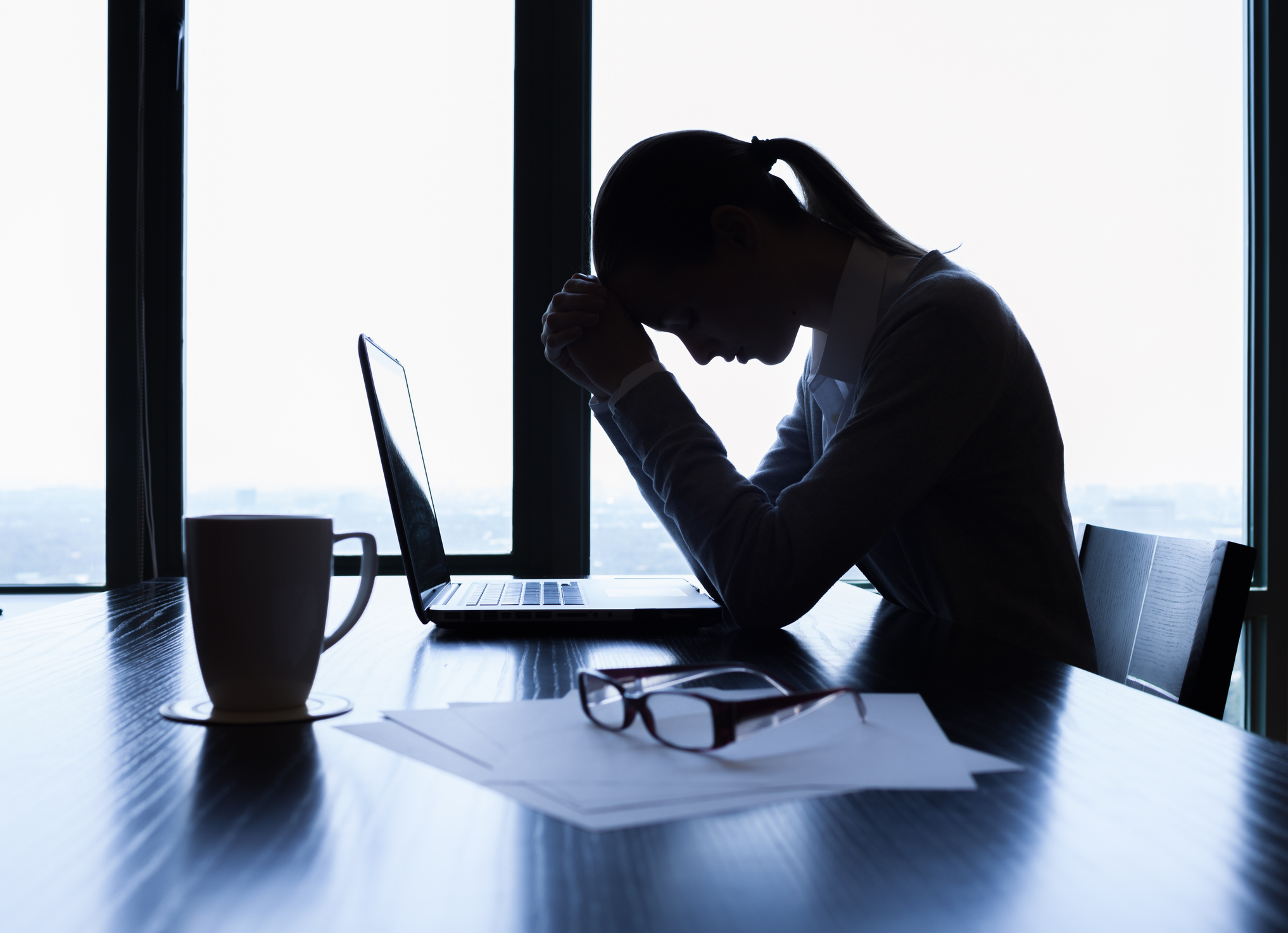 Silhouette of stressed businesswoman in the office.