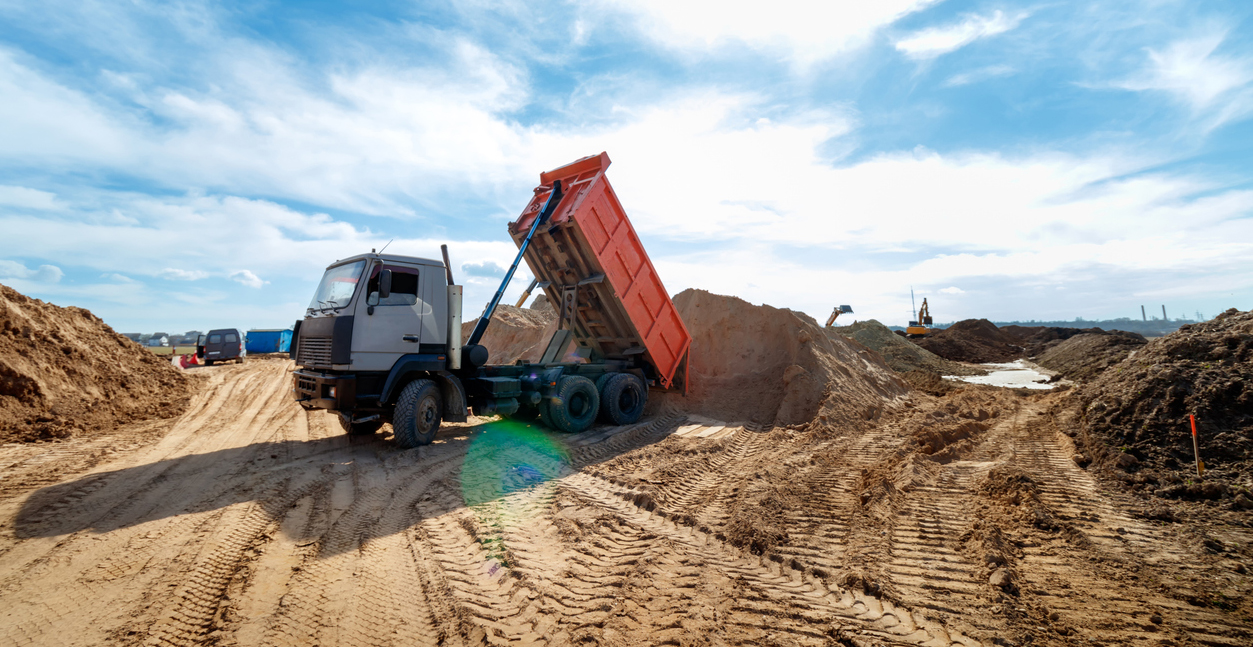 Delivery of sand to the construction site by truck with raised body.